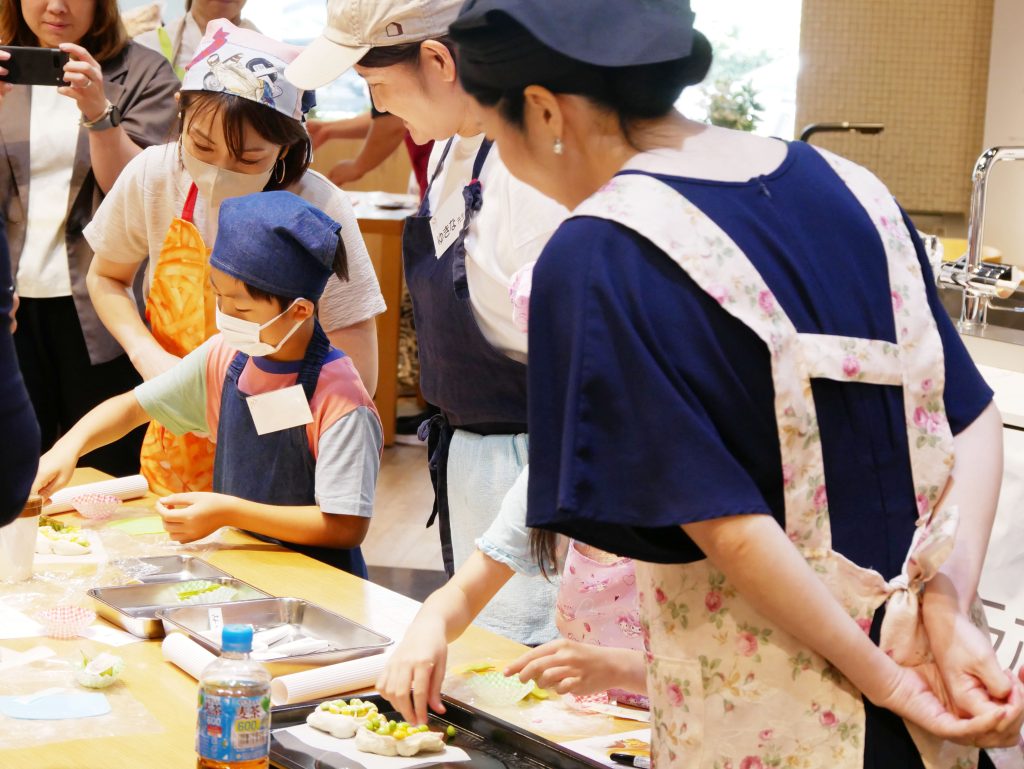 枝豆とコーンをトッピングする子どもたち